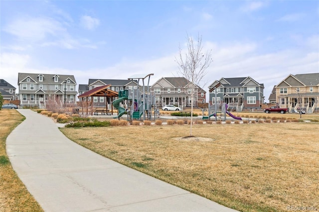 view of home's community featuring a residential view, playground community, and a lawn