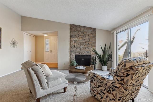 living room with vaulted ceiling, a stone fireplace, light carpet, and a textured ceiling