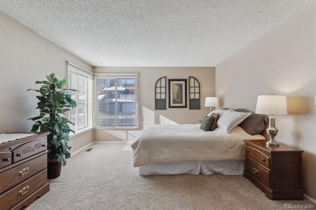 bedroom featuring light colored carpet and a textured ceiling