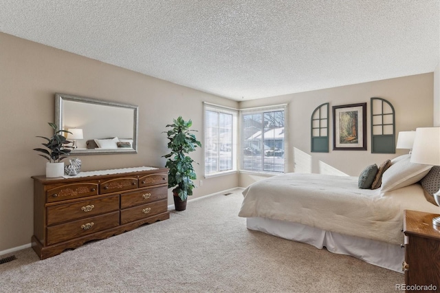 bedroom featuring light colored carpet and a textured ceiling