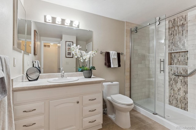 bathroom featuring an enclosed shower, vanity, tile patterned floors, and toilet