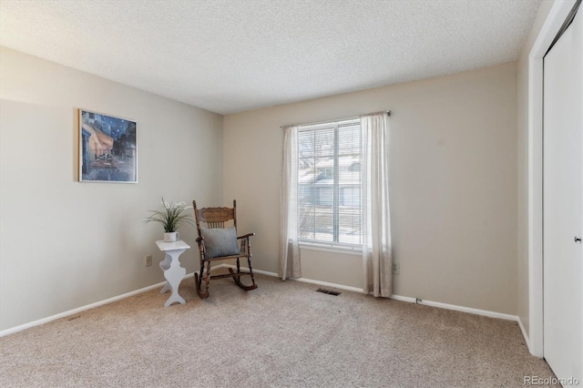 living area with light carpet and a textured ceiling