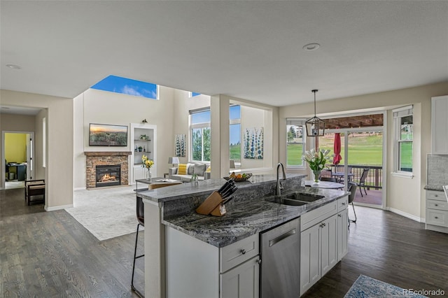 kitchen featuring a sink, a kitchen island with sink, dark wood-type flooring, and dishwasher