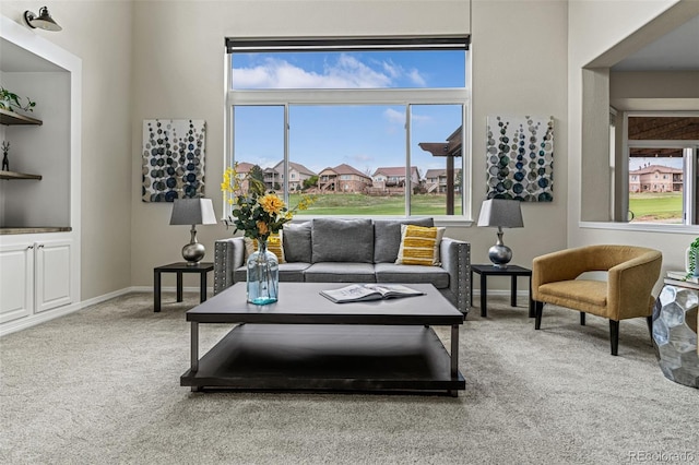 living room with baseboards, a wealth of natural light, and carpet