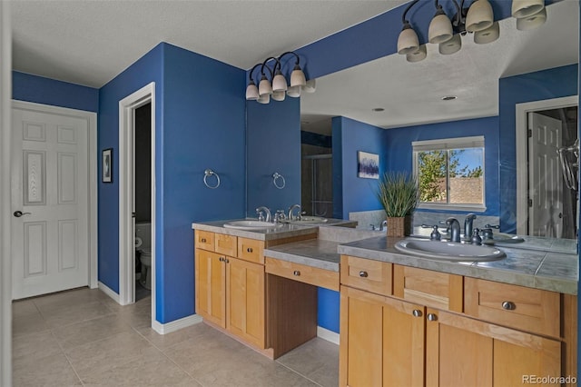 bathroom featuring double vanity, a sink, a textured ceiling, and a shower stall