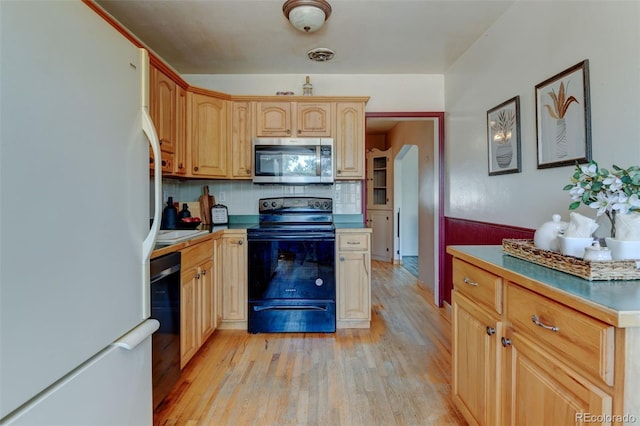 6788 Pierce Way, Arvada, CO 80003 - kitchen with freestanding refrigerator, stainless steel microwave, electric stove, light wood-style flooring, and decorative backsplash