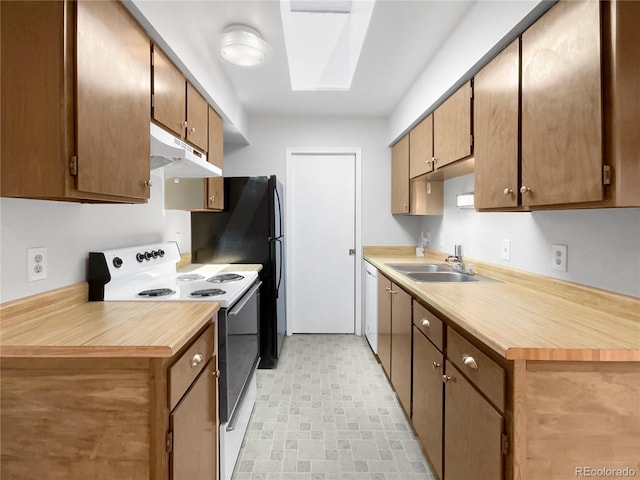 kitchen with white appliances, a skylight, and sink