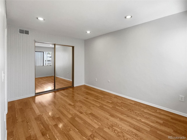 unfurnished bedroom with wood-type flooring and a closet