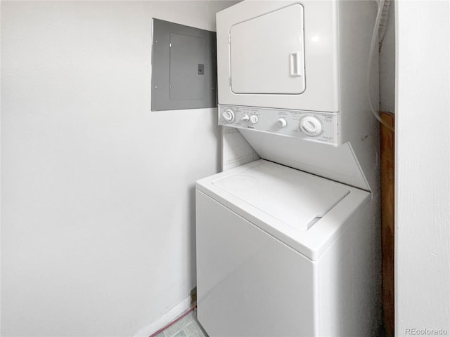 clothes washing area featuring stacked washer / dryer and electric panel