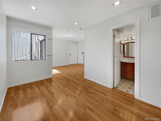 spare room with sink and light hardwood / wood-style flooring