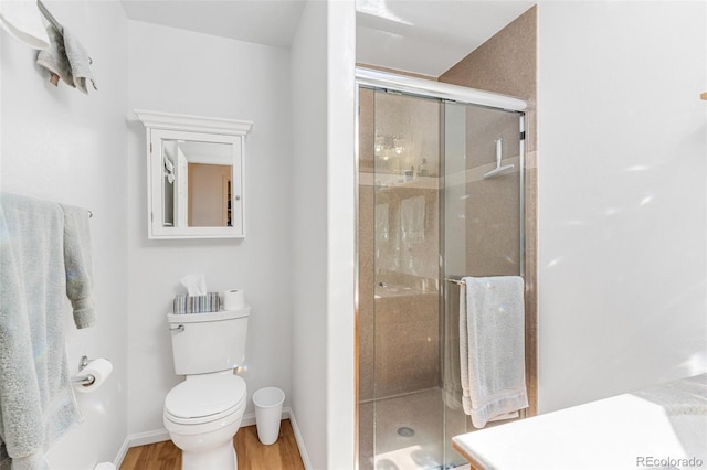 1041 Rockafellow Ct, Canon City, CO 81212 - bathroom featuring toilet, baseboards, a shower stall, and wood finished floors