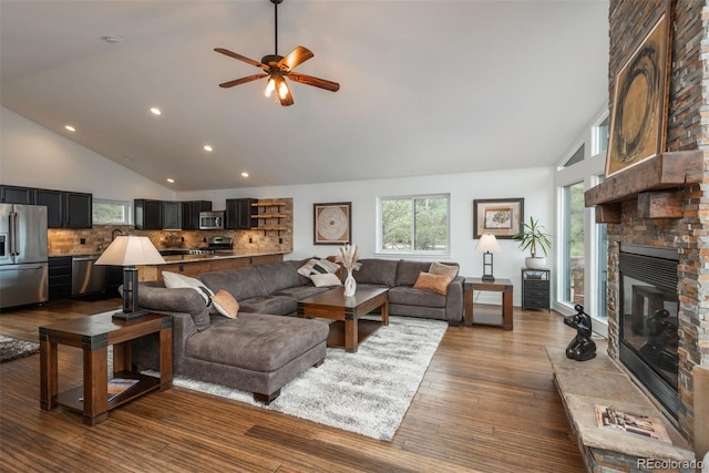 28364 Tresine Dr, Evergreen, CO 80439 - living room featuring recessed lighting, ceiling fan, high vaulted ceiling, a stone fireplace, and dark wood-type flooring