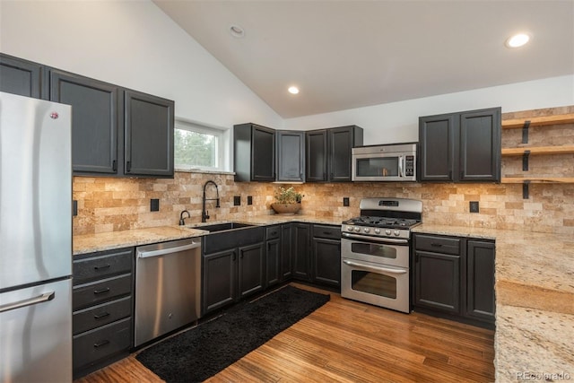 28364 Tresine Dr, Evergreen, CO 80439 - kitchen featuring appliances with stainless steel finishes, light stone countertops, tasteful backsplash, wood finished floors, and open shelves