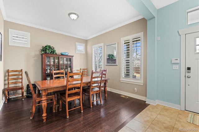 dining space with visible vents, crown molding, baseboards, and wood finished floors