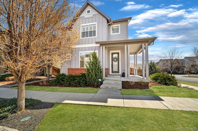 1950 W 67th Ave, Denver, CO 80221 - view of front facade featuring board and batten siding, a front lawn, and brick siding