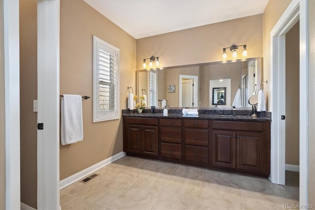 1950 W 67th Ave, Denver, CO 80221 - bathroom with visible vents, baseboards, a sink, double vanity, and tile patterned floors