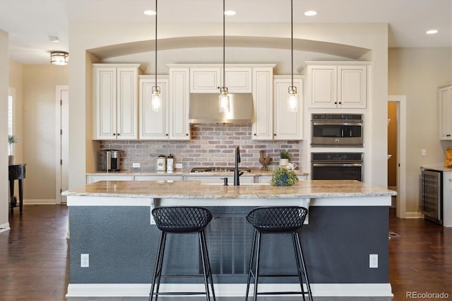 1950 W 67th Ave, Denver, CO 80221 - kitchen with dark wood finished floors, under cabinet range hood, baseboards, and beverage cooler
