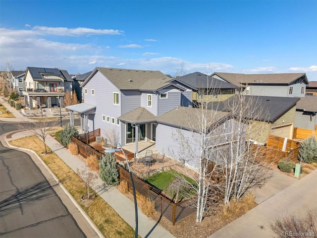1950 W 67th Ave, Denver, CO 80221 - view of front of house with roof with shingles, a patio area, fence, and a residential view