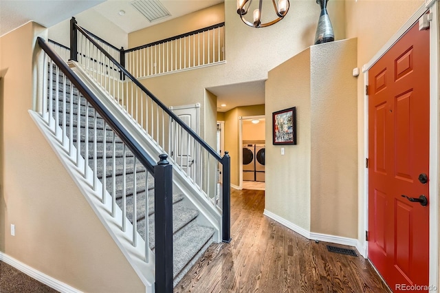 11522 Pine Grove Ln, Parker, CO 80138 - entryway featuring independent washer and dryer, baseboards, wood finished floors, a high ceiling, and stairway