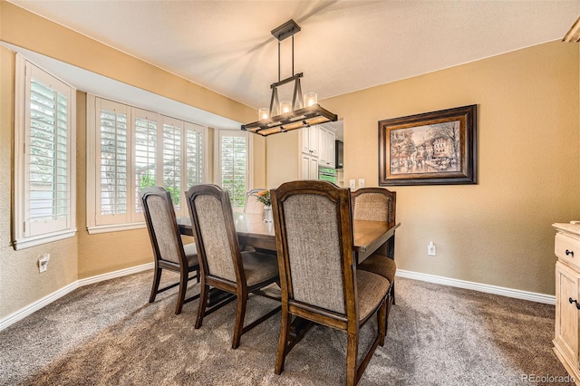 11522 Pine Grove Ln, Parker, CO 80138 - dining room with a textured wall, baseboards, dark colored carpet, and a chandelier