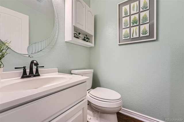 11522 Pine Grove Ln, Parker, CO 80138 - half bath with vanity, toilet, and wood finished floors