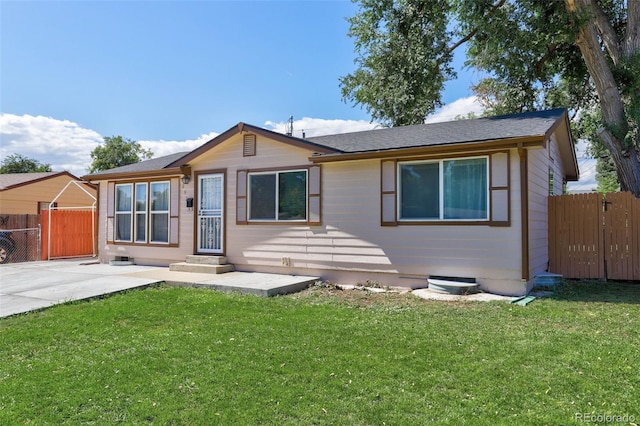 view of front of house with a patio, a front yard, and fence