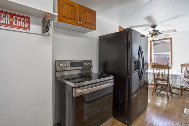 kitchen with light wood-type flooring, brown cabinets, black fridge with ice dispenser, stainless steel range with electric cooktop, and ceiling fan