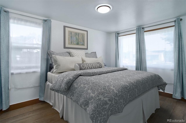 bedroom with wood finished floors and baseboards