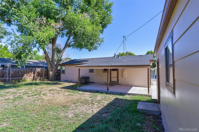 back of house featuring central air condition unit, a lawn, a patio, and fence