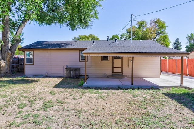 back of property with a yard, a patio, central air condition unit, and fence