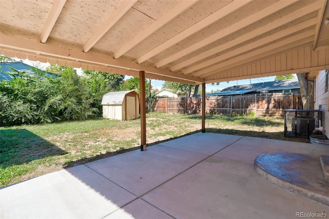 view of patio / terrace with an outdoor structure, a fenced backyard, and a shed