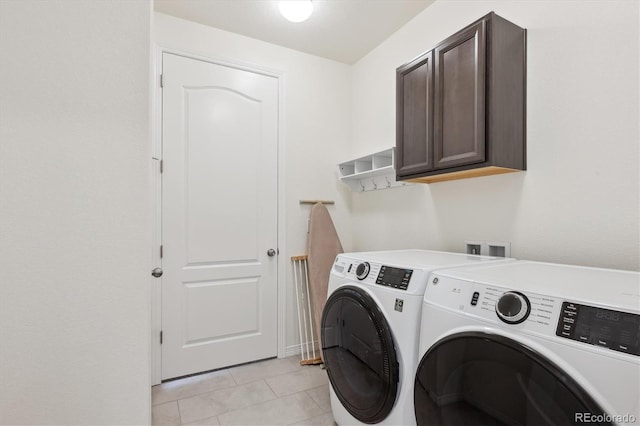 clothes washing area with cabinets, light tile patterned flooring, and independent washer and dryer