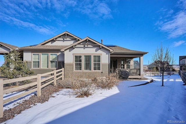 view of front of home with a porch and solar panels