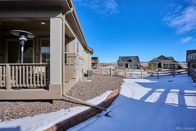 yard covered in snow featuring central AC unit