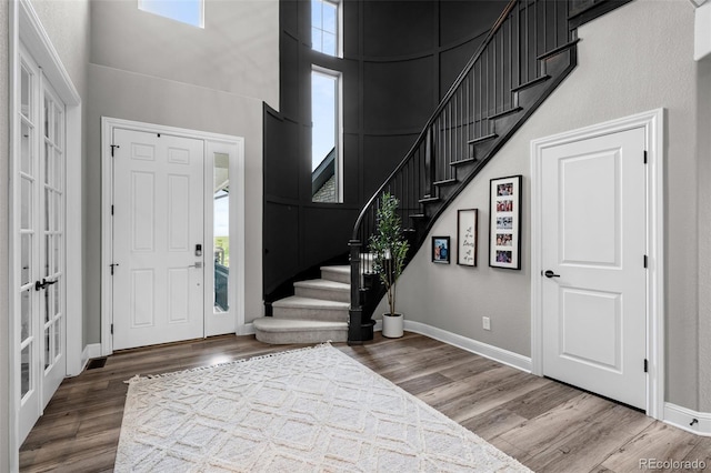 6737 S White Crow Way, Aurora, CO 80016 - entrance foyer with stairway, healthy amount of natural light, wood finished floors, and a high ceiling