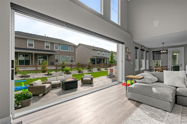 6737 S White Crow Way, Aurora, CO 80016 - living area featuring a towering ceiling, wood finished floors, healthy amount of natural light, and a chandelier