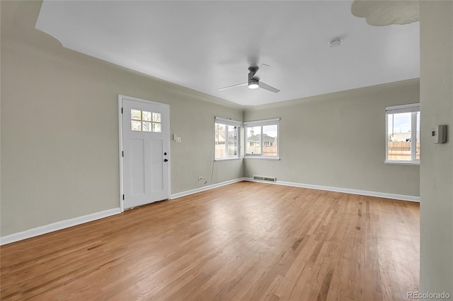 empty room with a ceiling fan, light wood-type flooring, baseboards, and a smoke detector