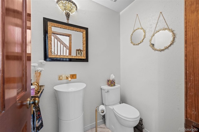 bathroom with toilet and baseboards