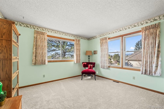 unfurnished room featuring a healthy amount of sunlight, a textured ceiling, visible vents, and carpet flooring