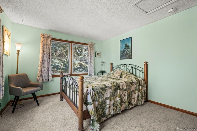 carpeted bedroom with attic access, a textured ceiling, and baseboards