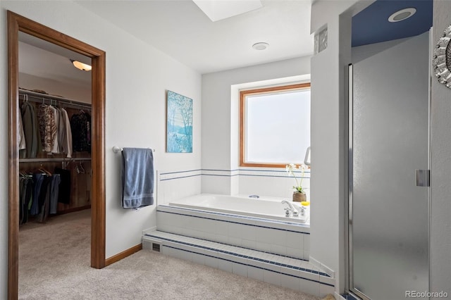 full bath featuring a walk in closet, a skylight, a shower stall, and a baseboard radiator