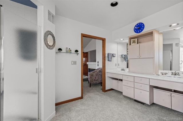 ensuite bathroom featuring carpet floors, a shower stall, and a sink