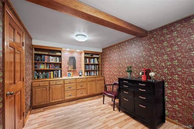 sitting room featuring light wood-style floors, beam ceiling, and wallpapered walls