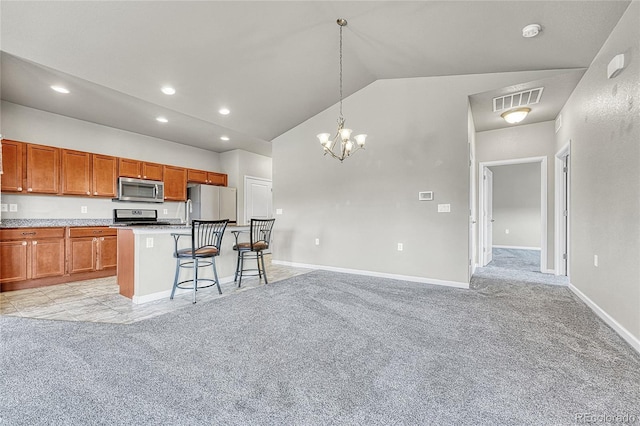 12444 Madison Way, Thornton, CO 80241 - kitchen featuring stainless steel microwave, freestanding refrigerator, stove, a breakfast bar area, and light carpet