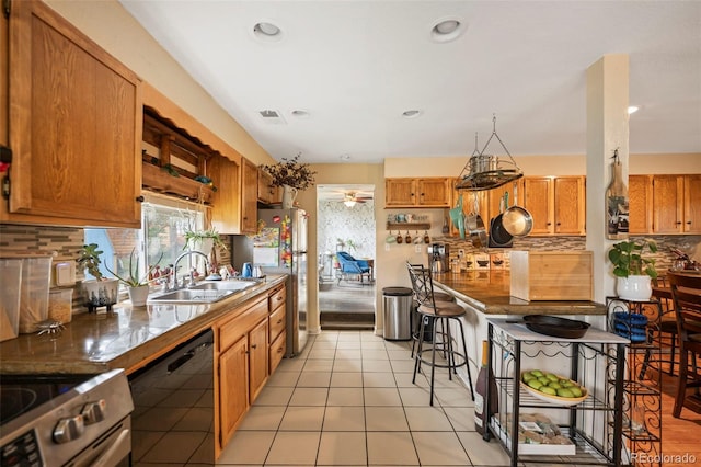 kitchen with appliances with stainless steel finishes, light tile patterned floors, tasteful backsplash, and sink