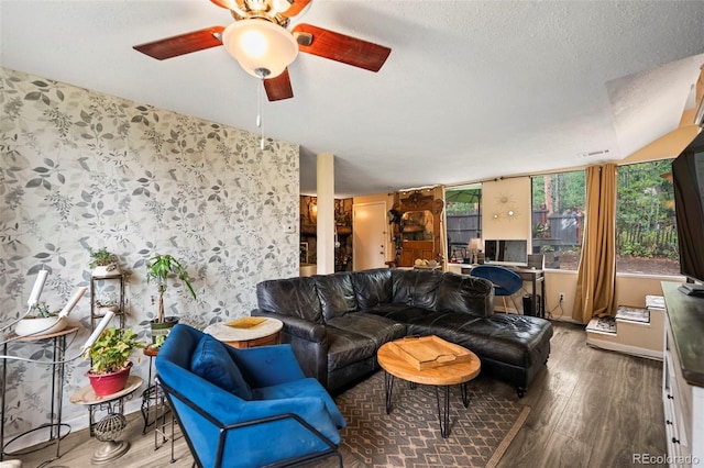 living room featuring hardwood / wood-style floors, ceiling fan, and a textured ceiling