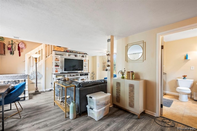 living room with a textured ceiling and wood-type flooring