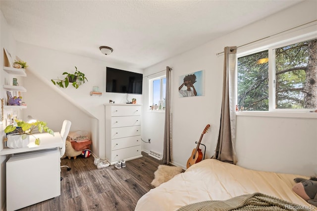 bedroom with a textured ceiling and dark hardwood / wood-style floors