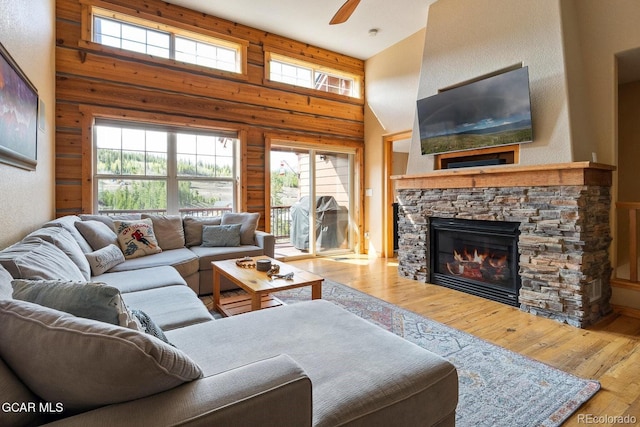 220 Reunion Ct, Fraser, CO 80442 - living area with hardwood / wood-style floors, a towering ceiling, a stone fireplace, a ceiling fan, and healthy amount of natural light