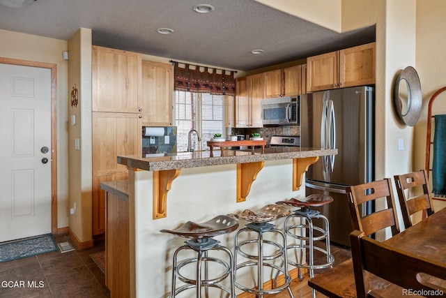 220 Reunion Ct, Fraser, CO 80442 - kitchen featuring stainless steel appliances, a breakfast bar, a kitchen island with sink, recessed lighting, and light countertops